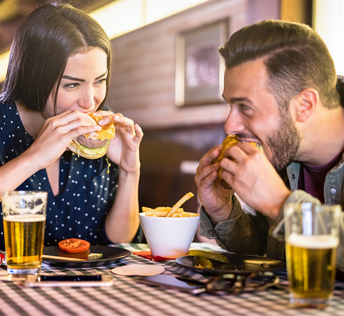 Man and woman enjoying burgers together in a restaurant