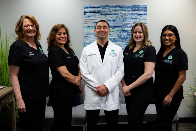 Doctor Pevzner smiling with four team members at Highland West Dental Care