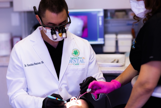 Doctor Pevzner wearing dental binoculars while treating a patient