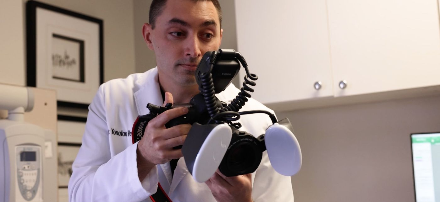 Austin dentist Doctor Yonatan Pevzner taking photographs of a patients teeth