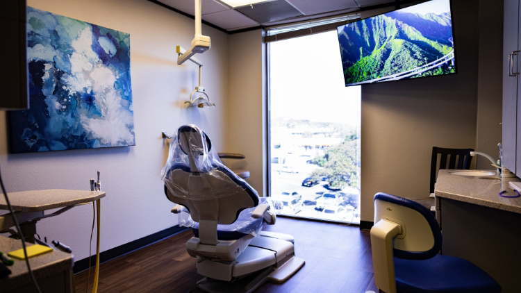Dental treatment room with a mounted wall television showing nature