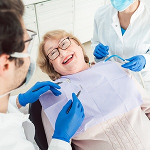 Senior woman smiling at dentist in treatment chair
