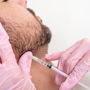 Man receiving BOTOX injection near his jaw