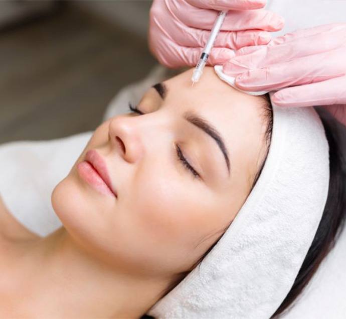 Woman relaxing while receiving BOTOX injection between her eyebrows